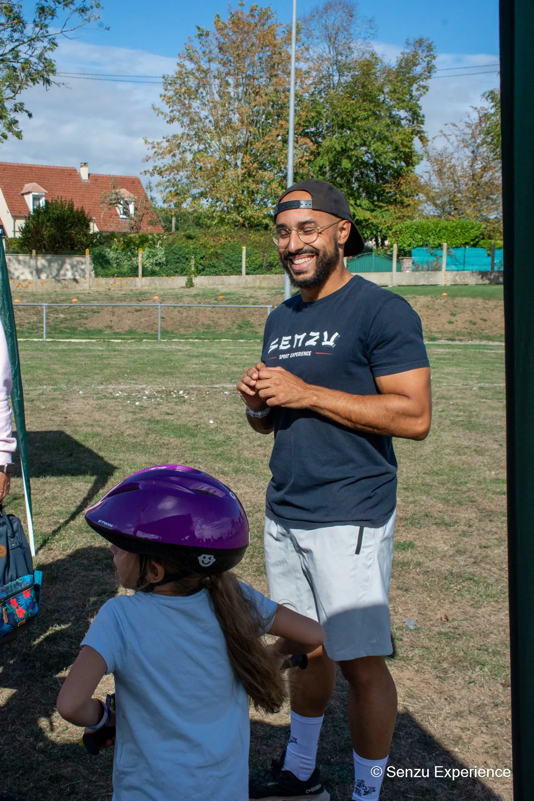 Un encadrant de SENZU Sport Exp&eacute;rience &eacute;change avec une enfant casqu&eacute;e avant son passage sur le parcours