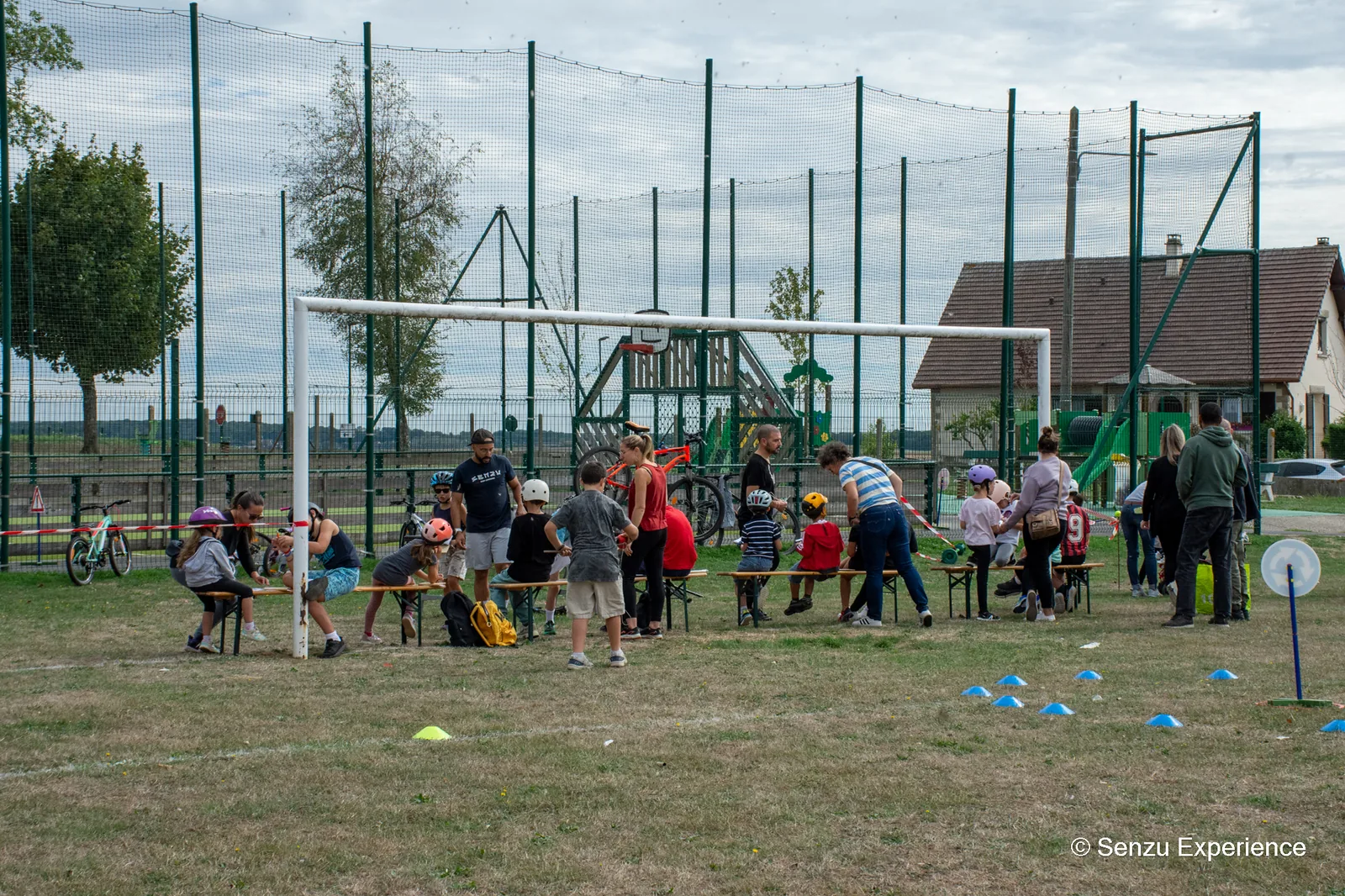 Les enfants et leurs parents rassembl&eacute;s autour des v&eacute;los, casque sur la t&ecirc;te, au stade de Villeneuve-les-Sablons
