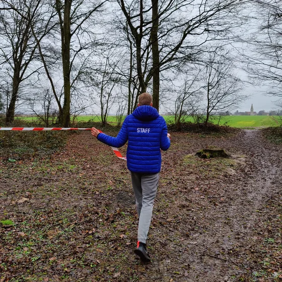 Bénévole STAFF qui pose la rubalise sur le parcours